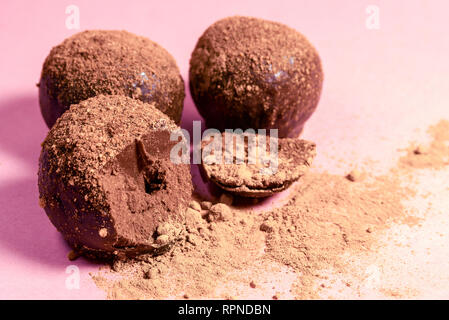 Bündel von Schokolade Cookies bestreut mit kleinen Muttern und Was. Eine Süßigkeit ist gebrochen. close-up. Hintergrund Stockfoto