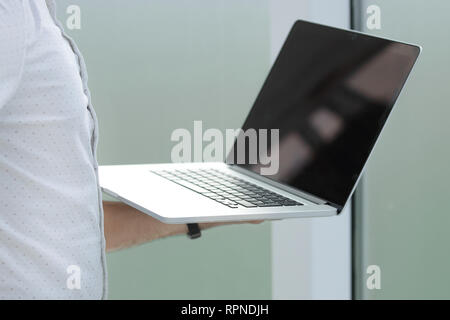 Bis zu schließen. Geschäftsmann mit Laptop im Büro. Stockfoto