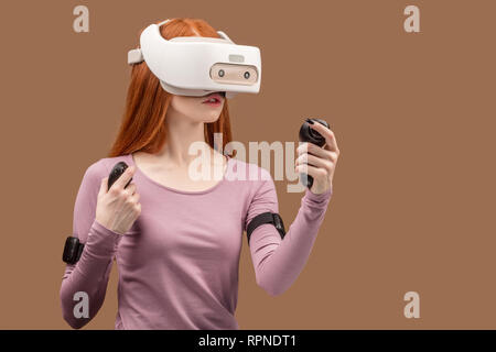 Kaukasische attraktives Mädchen erleben lebendige Eindrücke, virtuelle Realität, Helm, über Studio rosa Hintergrund isoliert Stockfoto