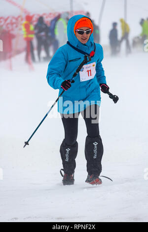 ALMATY KASACHSTAN 03 FEBRUAR 2019: Eine unbekannte Frau läuft durch einen Schneesturm während einer AlpineRas Wettbewerb in den Bergen im Winter Stockfoto
