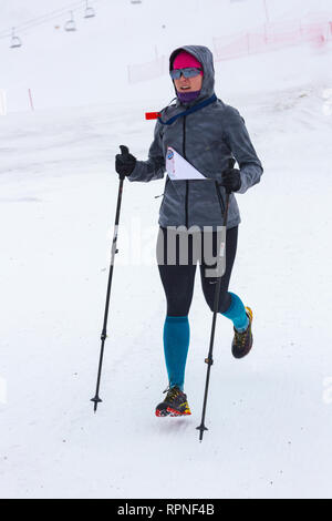 ALMATY KASACHSTAN 03 FEBRUAR 2019: Eine unbekannte Frau läuft durch einen Schneesturm während einer AlpineRas Wettbewerb in den Bergen im Winter Stockfoto