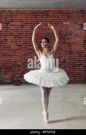 Anmutige junge talentierte Ballerina stehend auf Zehen und beiseite. Ausdauer und hobby Konzept. in voller Länge Foto Stockfoto