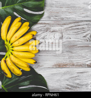 Raw Organic Gelb Baby Bananen in einem Bündel auf weißem Holz- Hintergrund der Ansicht von oben. Copyspace für Ihren Text, Banner Stockfoto