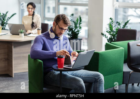 Ernsthafte bärtige männliche Notizen in Copybook Stockfoto