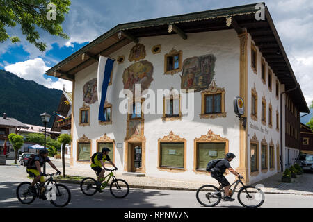 Eine Gruppe von Männern mit Fahrrädern an der Vorderseite eines traditionell bemalten Haus in Oberammergau in Bayern, Deutschland am 31. Mai 2018 Stockfoto