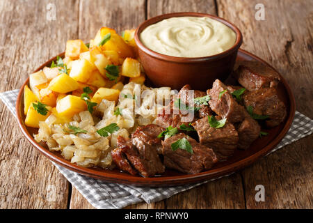 Gebratenes Rindfleisch Rydberg serviert mit Zwiebeln und frische Kartoffeln mit Senfsauce close-up auf einem Teller auf den Tisch. Horizontale Stockfoto