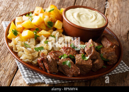 Schwedische Rindfleisch Rydberg mit gebratenen Zwiebeln und frische Kartoffeln mit Senfsauce close-up auf einem Teller auf den Tisch. Horizontale Stockfoto