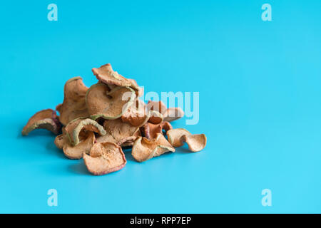 Getrocknete äpfel Slice in einem Haufen auf blauem Hintergrund, Zutaten für türkische Apfeltee, Hautnah. Hausgemachte sonnengetrockneten Bio Apfelscheiben. Stockfoto