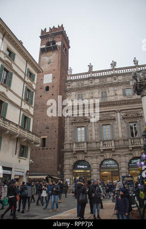 Italien, Verona - 08 Dezember 2017: Die Ansicht der Touristen an der Piazza delle Erbe mit Torre del Gardello und Maffei Palast auf dem Hintergrund. Stockfoto