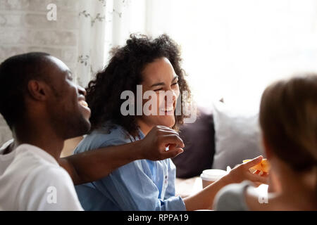 Glücklich lachend gemischten Rasse Frau essen Pizza, mit Freunden zu reden Stockfoto