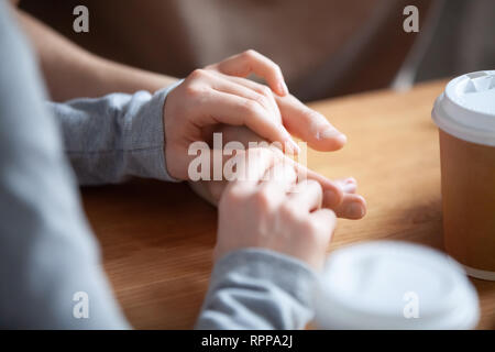 In der Nähe von Paar in Liebe im Cafe sitzen zusammen, halten sich an den Händen Stockfoto