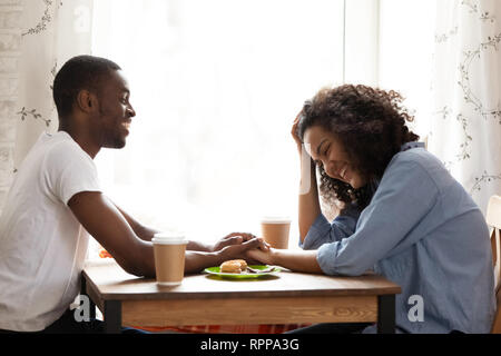 Happy African American man am Tag mit attraktiven Freundin im Cafe Stockfoto