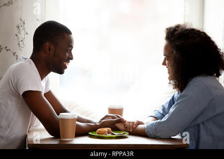 Happy gemischtrassiges Paar Hände halten, genießen im Cafe Stockfoto