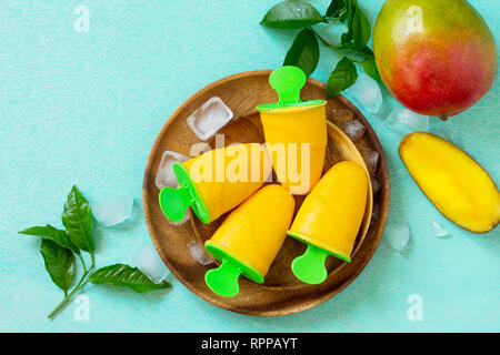 Gesund vegan orange mango Zitrusfrüchte Eis Popsicle. Sommer Nachtisch. Ansicht von oben flach Hintergrund. Stockfoto