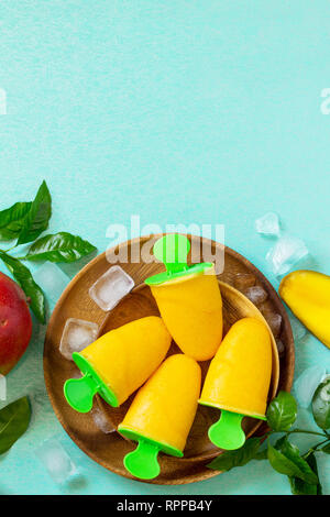 Gesund vegan orange mango Zitrusfrüchte Eis Popsicle. Sommer Nachtisch. Ansicht von oben flach Hintergrund. Kopieren Sie Platz. Stockfoto
