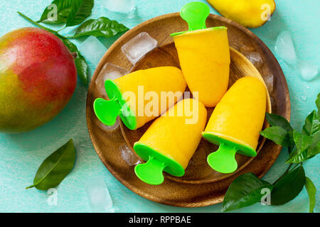 Gesund vegan orange mango Zitrusfrüchte Eis Popsicle. Sommer Nachtisch. Ansicht von oben flach Hintergrund. Stockfoto