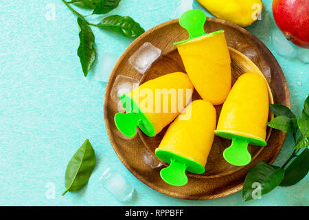 Gesund vegan orange mango Zitrusfrüchte Eis Popsicle. Sommer Nachtisch. Ansicht von oben flach Hintergrund. Stockfoto