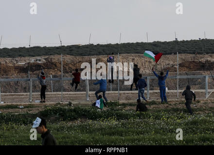 Gaza, Gaza, Gaza. 22 Feb, 2019. Palästinenser gesehen Klettern auf einem Zaun bei Auseinandersetzungen nach der großen Demonstration des '' Zurück '' Demonstration in Iyya Shuja" Viertel von Gaza, Gaza. Credit: nidal Alwaheidi/SOPA Images/ZUMA Draht/Alamy leben Nachrichten Stockfoto