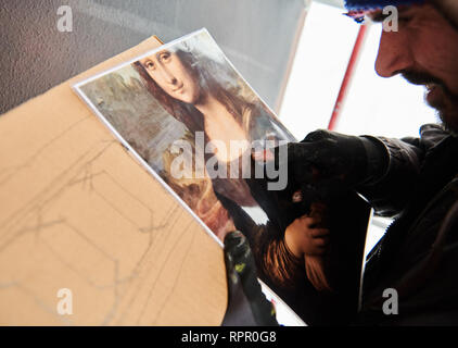 Berlin, Deutschland. 21 Feb, 2019. Feldspritze Uwe zeigt auf ein Bild der Mona Lisa. Es ist die Vorlage für ein großes Bild, dass die Künstler von Xi-Design auf die Hauswand gegenüber der East Side Gallery an. Quelle: Annette Riedl/dpa/Alamy leben Nachrichten Stockfoto