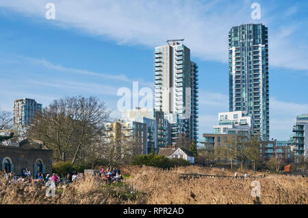 Menschen außerhalb Cafe Woodberry Feuchtgebiete, nördlich von London UK, mit neuen Apartment Gebäude im Hintergrund, an einem sonnigen Tag im Winter Stockfoto