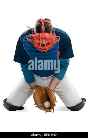 Baseballspieler fing einen Ball mit einem Leder Mitt. Mann verkleidet in einem einheitlichen und trägt ein Zahnrad, saß auf seinem Knie. Stockfoto