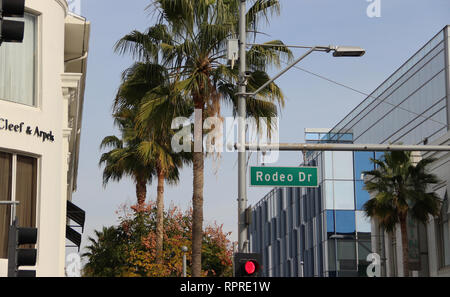 Rodeo Drive Straßenschild in Beverly Hills, Kalifornien mit Palmen im Hintergrund. Dieser berühmten Straße verfügt über High-end Luxury Stores und Händler. Stockfoto