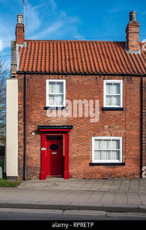 Englisches Dorf Red Brick freistehendes Haus mit roten Tür in Markt, Tickhill in der Metropolitan Borough von Doncaster, South Yorkshire, England, Stockfoto