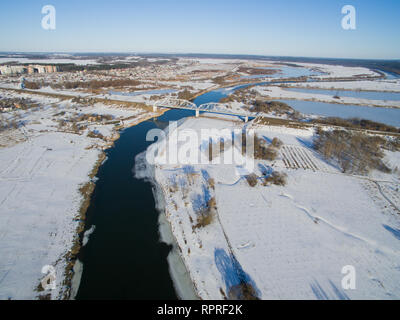 Foto von oben mit Straßen, Gebäude, Brücken, Fluss an einem Wintertag. Antenne Blick auf die Stadt mit Autos. Stockfoto