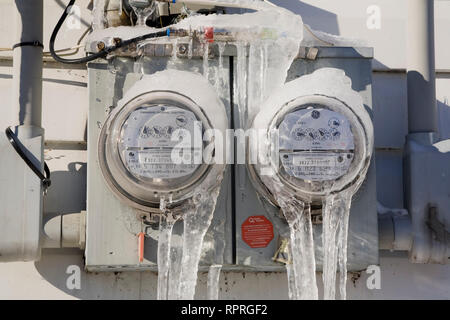 Close-up Eis bedeckt hydro Stromverbrauch m auf der Außenwand eines Wohnhaus im Winter Stockfoto