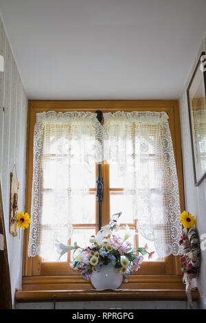 Keramik Vase mit Seide Blumen auf der Fensterbank eines alten 1983 rekonstruierte Canadiana Landhausstil Home Log Stockfoto