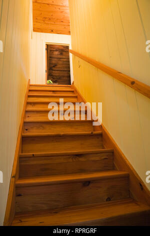 Kiefernholztreppen führen in die obere Etage in einem alten Haus im Stil eines 1722 Jahre alten Cottage. Stockfoto