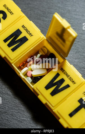 Pillen in Feld mit Datum. Verschiedene Medikamente pro Tage und Stunden getrennt. Plan für Arzneimittel. Medizinisches Konzept mit Bunker. Stockfoto