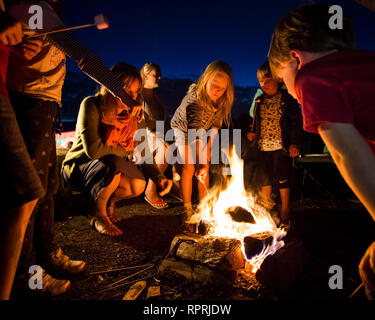 Kinder toasten Marshmallows über einem Lagerfeuer auf einem Campingplatz in Sussex, UK Stockfoto