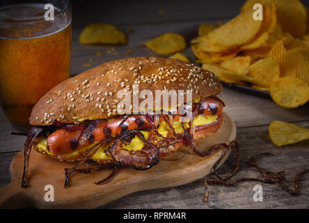 Frische Hot Dog mit gegrillten Würstchen, Chips und Bier Stockfoto