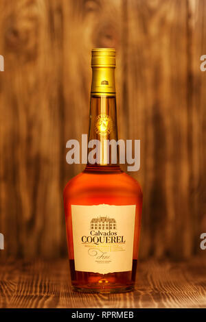 2019, 23. Februar, Minsk, Belarus - Flasche Calvados Coquerel in jungen Eichenfässern auf Holztisch im Alter von Stockfoto