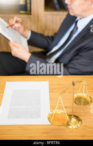 Rechtsanwalt Richter Lesen von Dokumenten am Schreibtisch im Gerichtssaal Arbeiten am Schreibtisch aus Holz Hintergrund. Hammer golden Gewicht. und soundblock des Gerichtshofs Stockfoto
