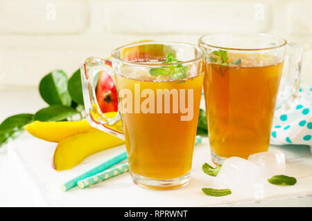 Obst Kaffee Tassen. Eistee Mango mit Minze auf rustikalen weißer Tisch. Stockfoto