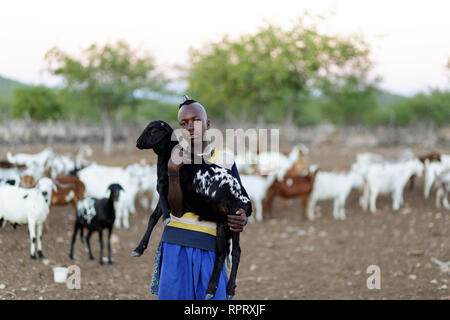 Himba Jungen kümmert sich um Ziegen, Epupa, Namibia, Afrika Stockfoto