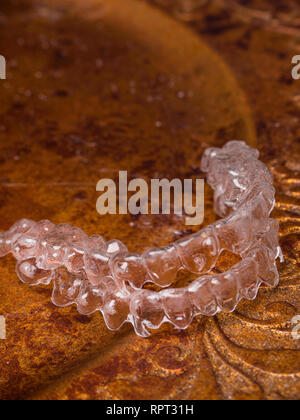 Zähne Aligner. Unsichtbare Klammern auf Gold Platte/ lächeln Konzept Stockfoto