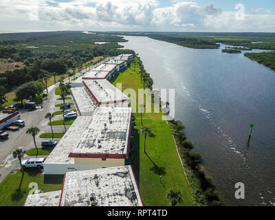 Geschäftsgebäude in einer Reihe auf der Riverfront Antenne Drone Schuß Natur tagsüber Stockfoto