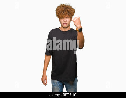 Junger stattlicher Mann mit afro Haar zu tragen schwarze T-Shirt verärgert und wütend die Faust frustriert und wütend, während Schreien vor Wut. Wut und aggressi Stockfoto