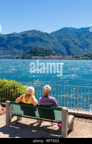 Touristen Blick auf Bellagio von einer Bank am Ufer des Comer See, Lombardei, Italien Stockfoto