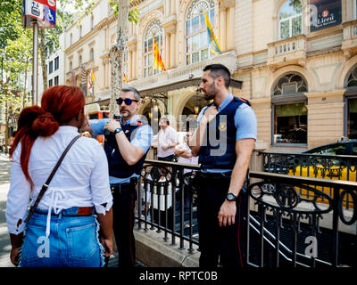 BARCELONA, SPANIEN - Jun 1, 2018: Polizisten helfen, Einheimische, Touristen und Menschen mit Richtung auf der berühmten Rambla dels Estudis Straße Stockfoto