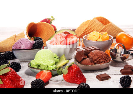 Satz von Eis Kugeln in verschiedenen Farben und Geschmacksrichtungen mit Beeren, Schokolade und Früchte auf dem Tisch Stockfoto