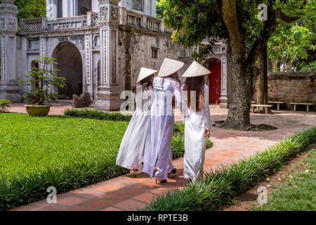 Junge vietnamesische Frauen, die die traditionelle Kleidung Ao Dai und der Konischen hat nicht La Lage; Tempel der Literatur in Hanoi, Vietnam Stockfoto