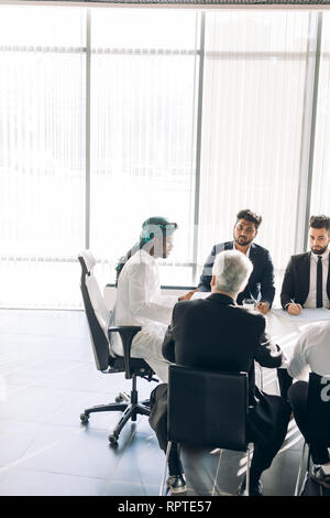 Fokusgruppe von Werbeagentur männliche Material in Anzügen sitzen, unter der Leitung von Executive gekleidet, gekleidet in arabischen Art und Weise, die Interaktion in Boardroo Stockfoto