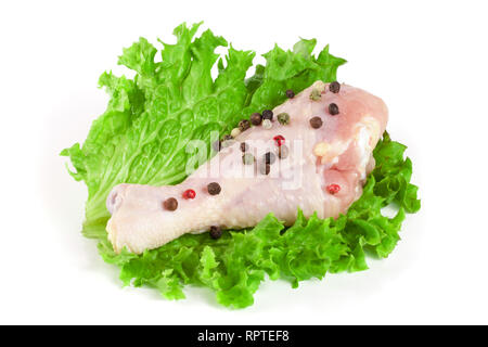 Ein rohes Huhn drumstick mit Salatblatt auf weißem Hintergrund Stockfoto