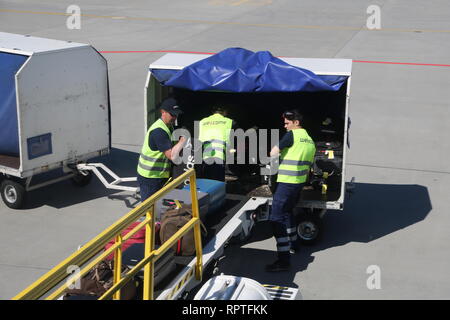 Gepäckabfertigung in Posen Flughafen Lawica Ort Beutel arbeiten auf das Transportband Laden einer Ryanair Boeing 737. Stockfoto