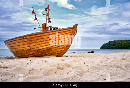 Sandstrand mit alten hölzernen Fischerboot an der Ostsee in Binz. Insel Rügen, Deutschland Stockfoto