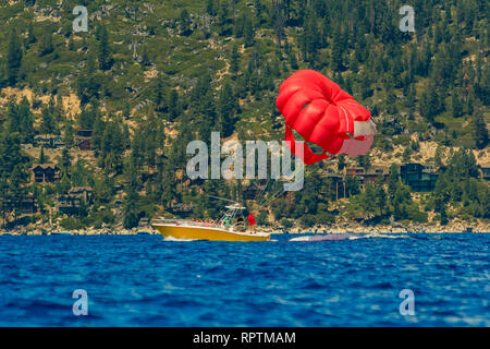 Red parasail Kotflügel durch ein Boot am Lake Tahoe in Kalifornien, USA, gezogen Stockfoto